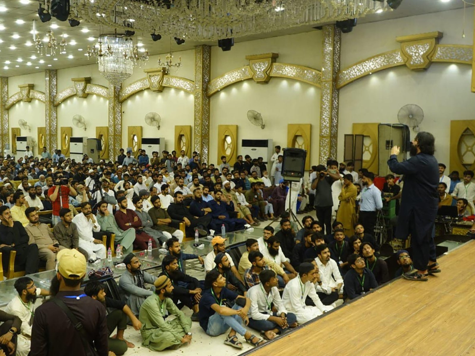 Side view of large audience seated in rows during the session